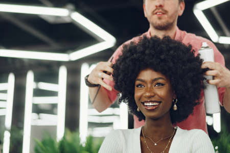 Young african woman customer getting a hairstyle at a beauty salon.の写真素材
