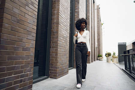 Portrait of attractive young woman walking outside in the cityの写真素材