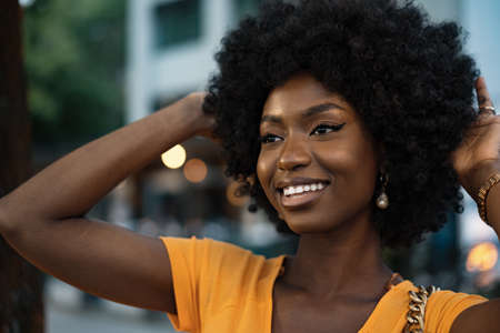 Portrait of a young african american woman smiling standing at the city.の写真素材