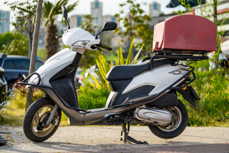 Food delivery motorbike with isothermal box parked on streetの写真素材