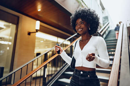 Young smiling african woman poses near stairs in the cityの写真素材