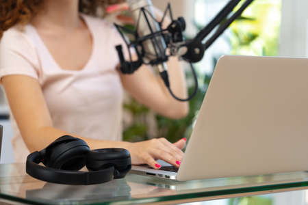 Close up of a woman recording a podcast in a studioの写真素材