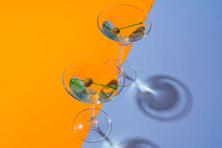 Two classic dry martini with olives on color background.の写真素材