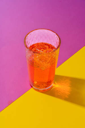 Glass of fresh cocktail on color backgroundの写真素材