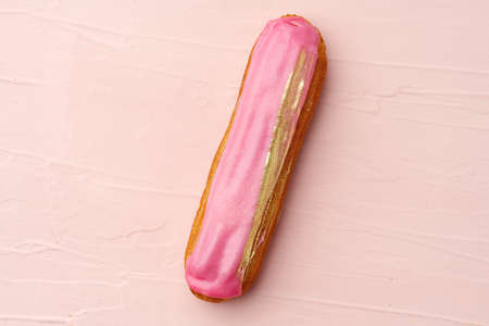 Eclair dessert with icing on pink wooden backgroundの写真素材