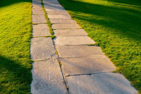 Stone footpath on a green grass in the park