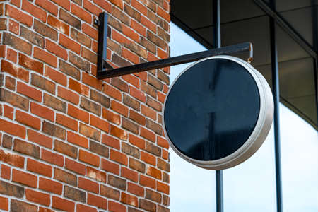 Empty black round signboard on the brick wallの写真素材
