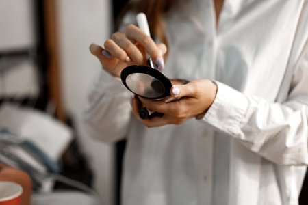 Close up of a woman applying face powder on brush