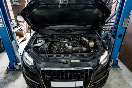 View of engine and other parts under the open hood of a car