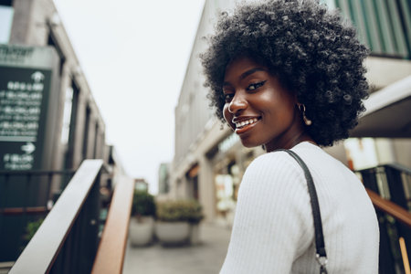 Young smiling african woman poses near stairs in the cityの写真素材