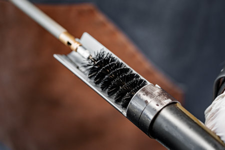 Close up of a gunsmith cleaning firearm barrel with ramrod brushの写真素材