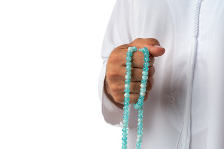 Close up of unrecognizable arab man in traditional dress holding beads against white backgroundの写真素材
