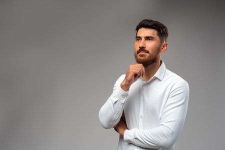 Studuo shot of thinking businessman standing over gray background