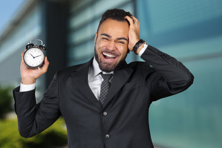 Black businessman with alarm clock. Time management conceptの写真素材