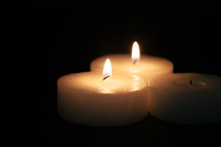 the light of the candle illuminates the darknessの写真素材