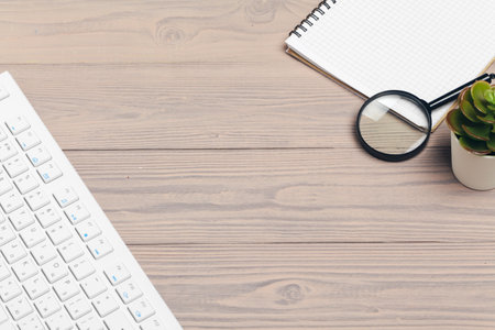 Office equipment such as computer keyboard and other supplies on wooden tableの写真素材