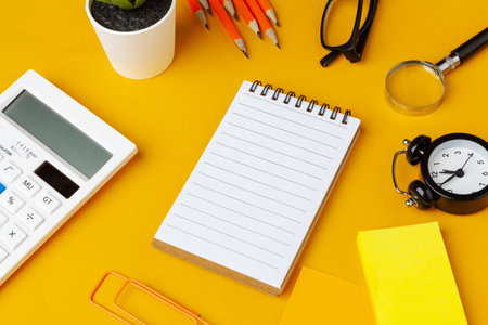 Stylish messy yellow desk top with various stationery top view