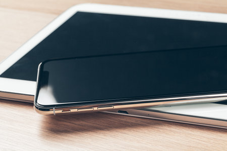 Digital tablet and mobile phone. Electronic devices on wooden table, close up.の写真素材