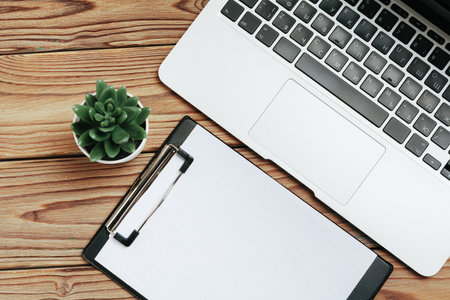 Business work place with equipment on wooden desk, top view