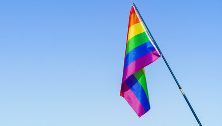 LGBT waving flag in the sky on flagpole