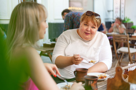 Portrait of two women, a mother and her daughter sitting in a cafeの写真素材