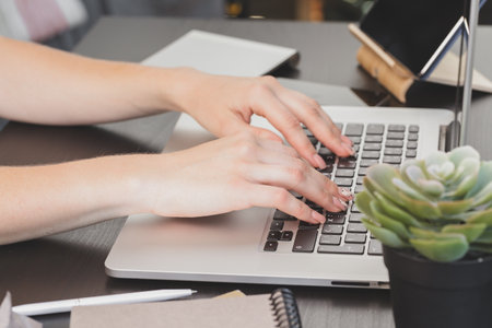Close up of a female hands of woman office worker typing on the keyboard