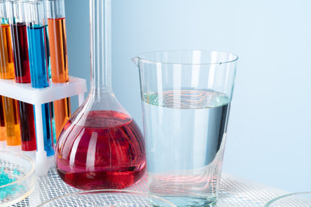 Chemical laboratory glassware with various colored liquids on tableの写真素材