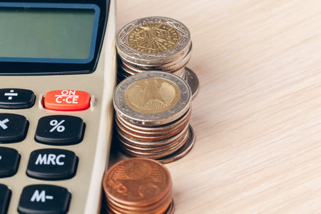 Close up of a calculator and coins on a business backgroundの写真素材