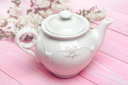 White ceramic tea kettle on wooden table close upの写真素材