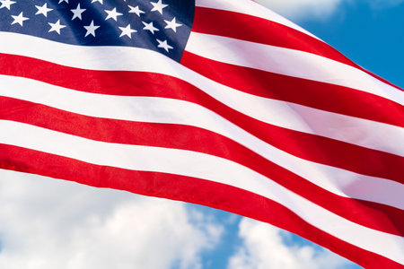 American flag waving in the wind against blue skyの写真素材