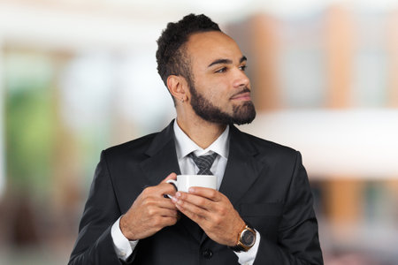 African american businessman wearing suit and holding coffee cup. Coffee breakの写真素材