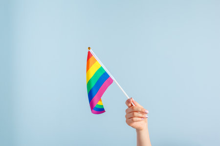 Gay flags in womens hand on grey backgroundの写真素材