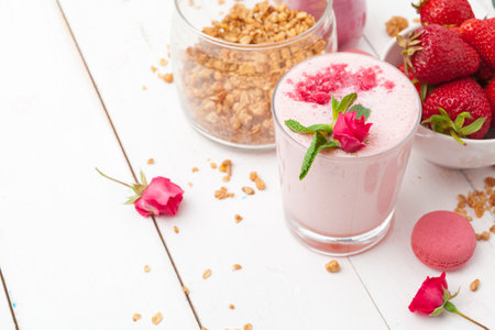 Healthy breakfast with yoghurt, granola and strawberries on white wooden background top viewの写真素材