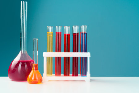 Chemical laboratory glassware with various colored liquids on table