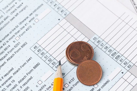 The close-up of accounting documents with money coinsの写真素材