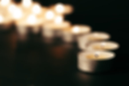 Burring candles on decorative glass. Dark background. Blurの写真素材