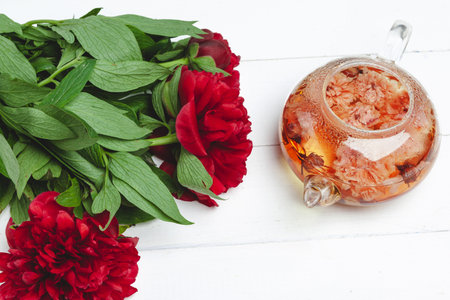 Glass kettle of herbal tea with fresh flowers close upの写真素材