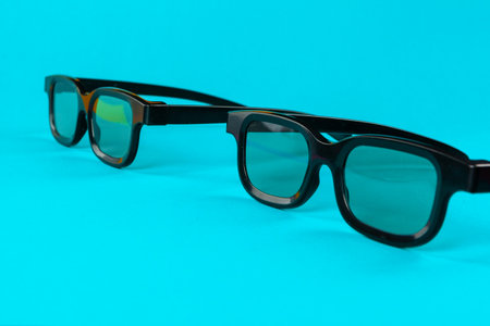 Pair 3D glasses on blue background. Flat lay.