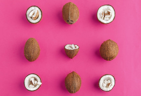 Broken coconut pieces on bright pink background, top view, copy spaceの写真素材