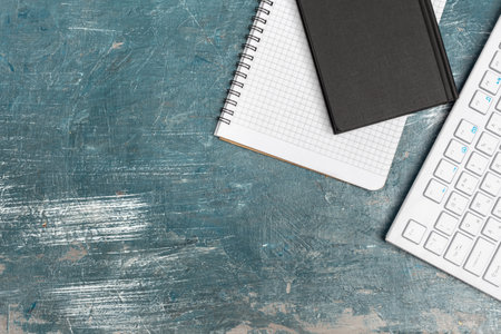 Office table with note paper, computer keyboard and supplies close upの写真素材