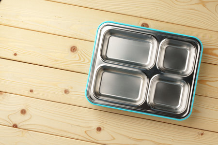 Metal lunch box with compartments on wooden backgroundの写真素材