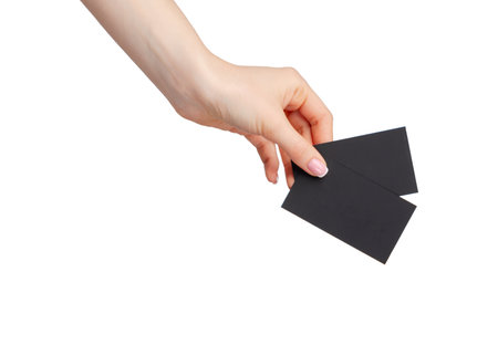 Female hand holding black businesscard isolated on white backgroundの写真素材