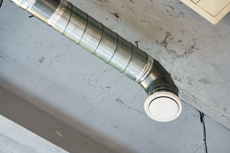 Silver ventilation pipes hanging from the ceiling inside the building