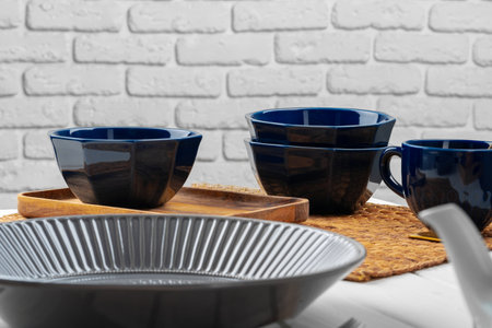 Glossy grey ceramic plate with cutlery on wooden table