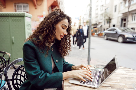 Young woman using laptop in the outdoor cafeの写真素材