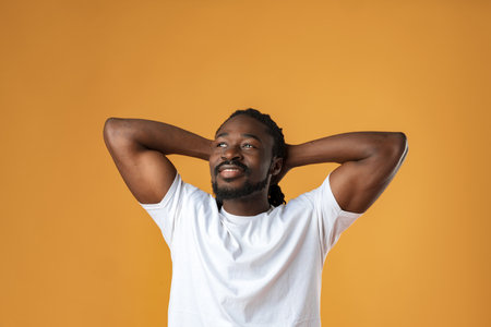Handsome smiling young african man standing isolated over yellow backgroundの写真素材