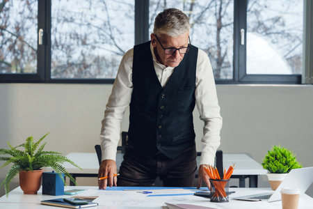 Mature businessman working at the desk in office.