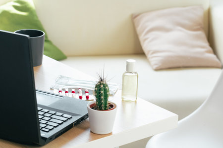 Working place table with small bottle of antibacterial sanitizerの写真素材