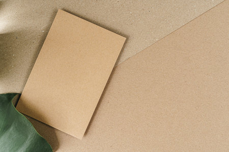 Flat lay craft paper card mockup with leaves