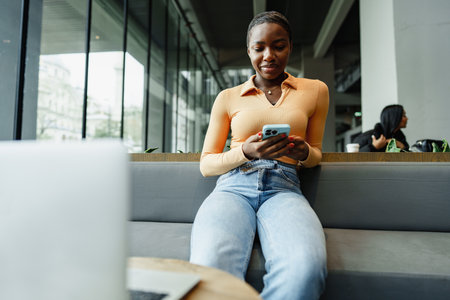 African female student working on computer in public placeの写真素材
